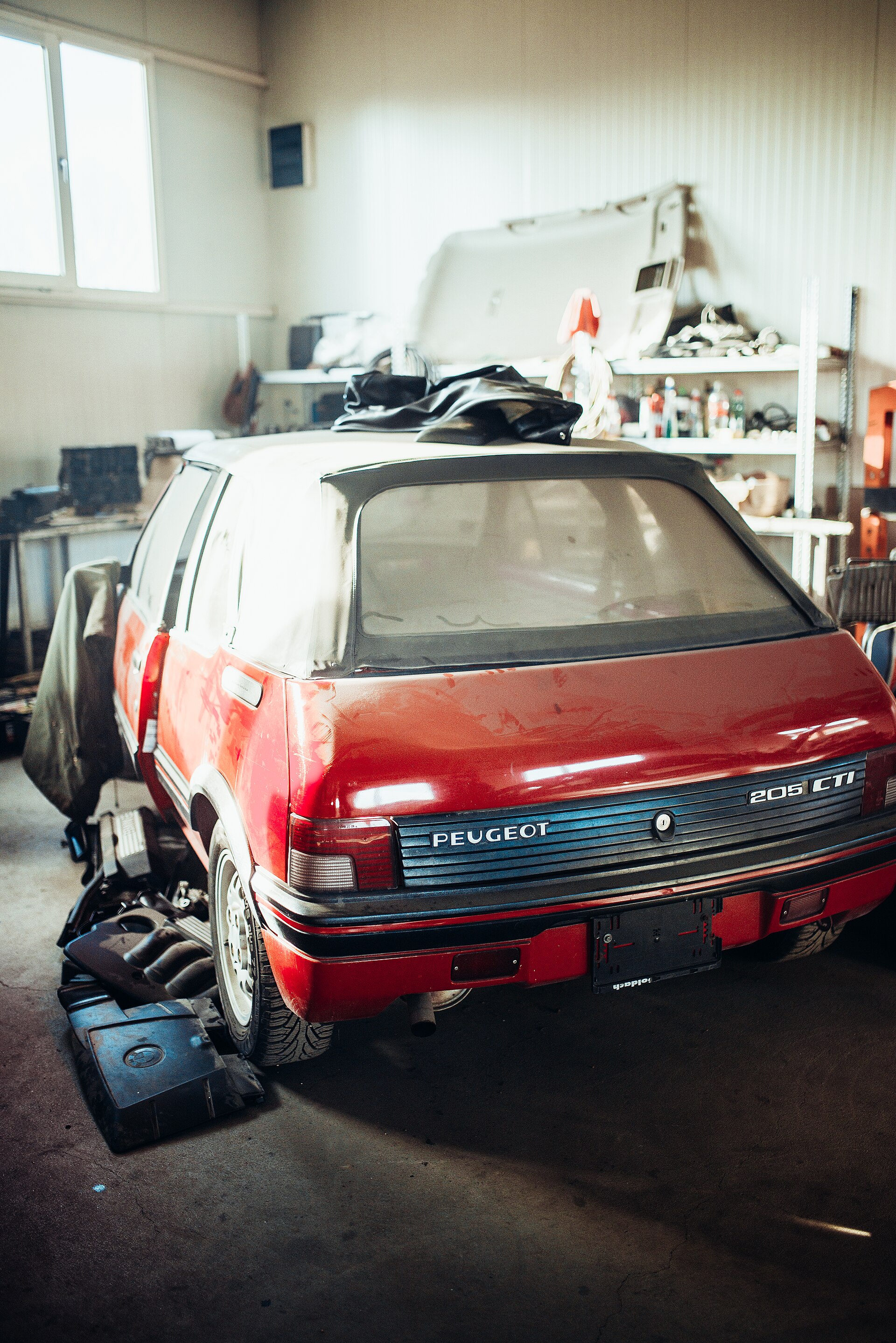 Stary czerwony Peugeot czeka na naprawę w warsztacie