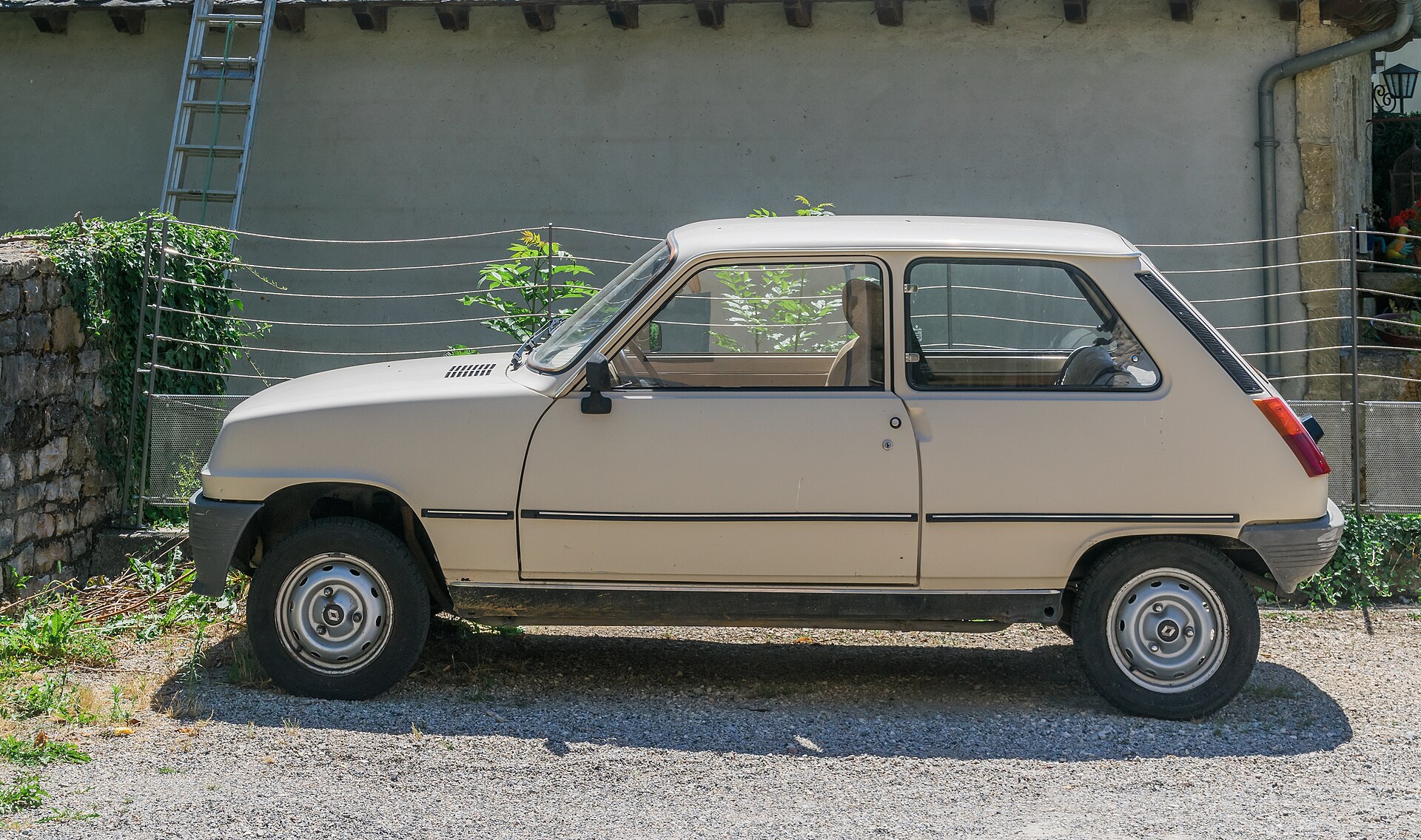 Beżowe Renault 5 TL zaparkowane przy murze